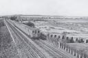 A short Central Line train between Fairlop and Barkingside in April 1955. Note the tank traps and allotments, beyond is the old airfield, eventually to become Fairlop Waters Country Park. Credit: Alan A Jackson