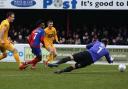 Alexander McQueen of Dagenham slots a rebound past O's keeper Dean Brill (Pic: Gavin Ellis/TGS Photo)